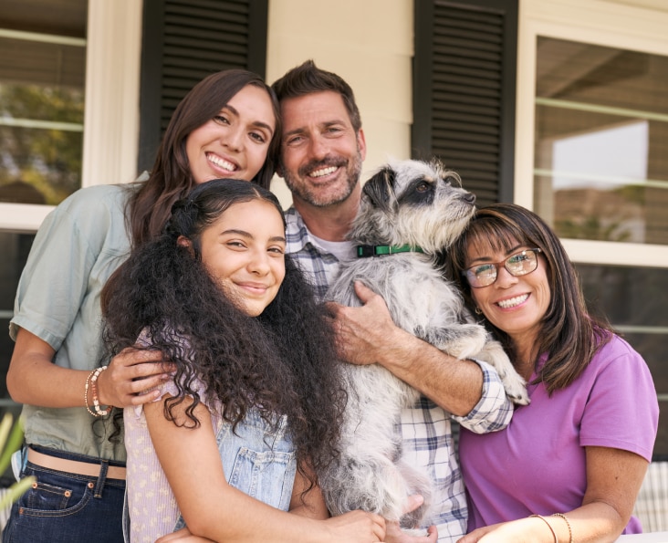 Happy family smiling together with their dog